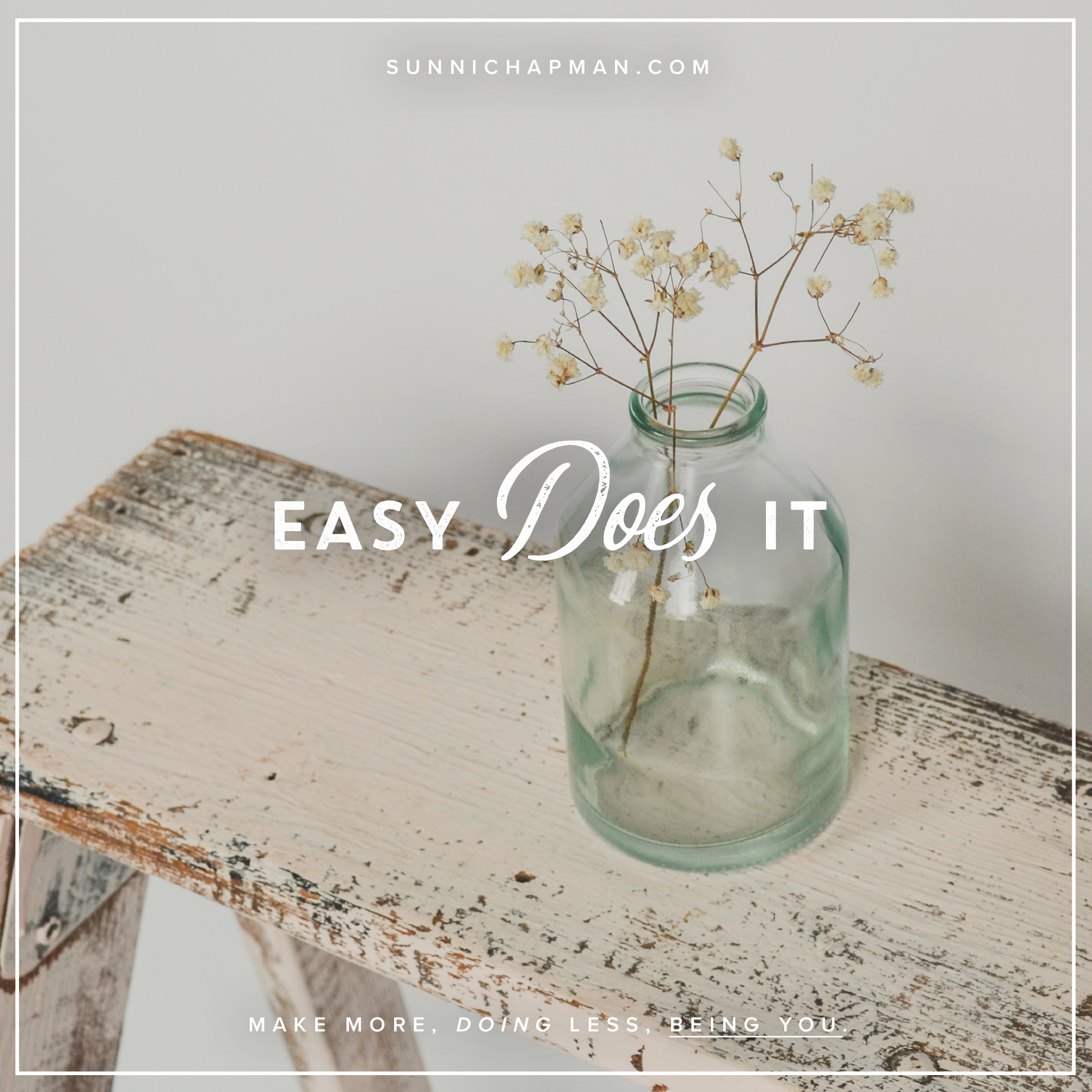 Easy Does It text as a cover on the white wall with a table, and glass bottle with white flowers 